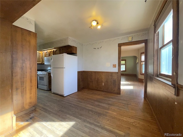 kitchen with white appliances and hardwood / wood-style flooring