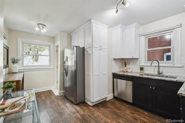 1633 Gaylord St, Denver, CO 80206 - kitchen with stainless steel appliances, a sink, light stone counters, and dark wood-type flooring