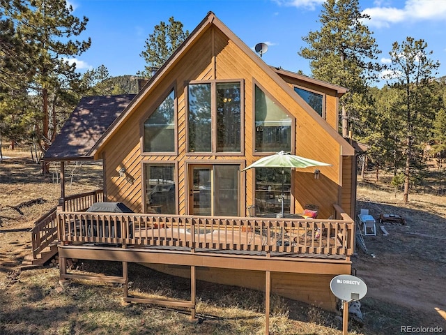 rear view of house featuring a wooden deck