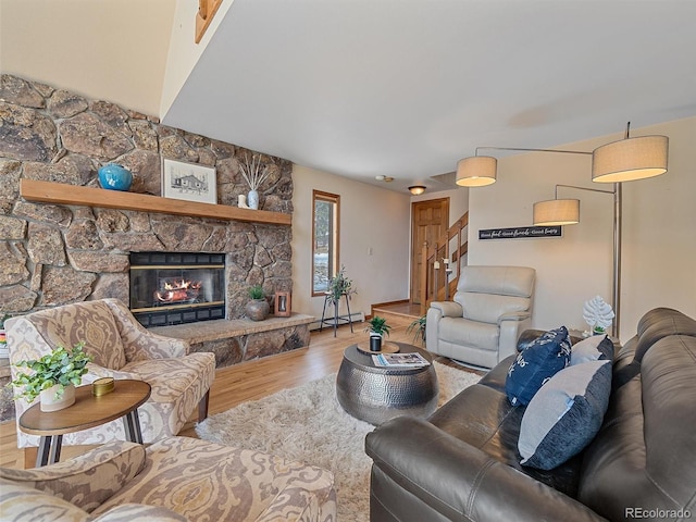 living room featuring a fireplace, stairs, a baseboard heating unit, and wood finished floors