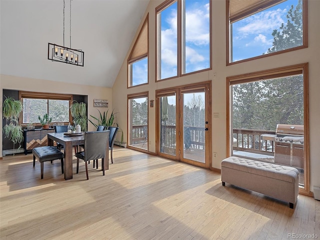 sunroom / solarium featuring plenty of natural light, an inviting chandelier, and vaulted ceiling