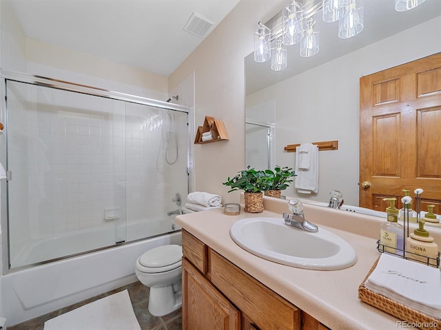 bathroom with vanity, toilet, visible vents, and combined bath / shower with glass door