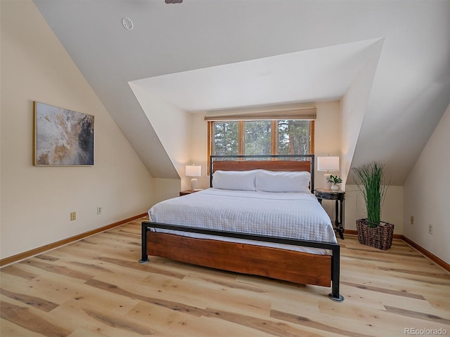 bedroom featuring vaulted ceiling, baseboards, and wood finished floors