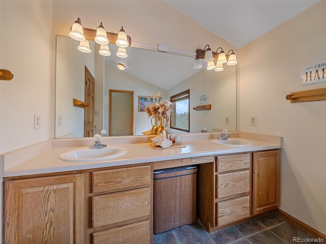 bathroom with lofted ceiling, double vanity, baseboards, and a sink