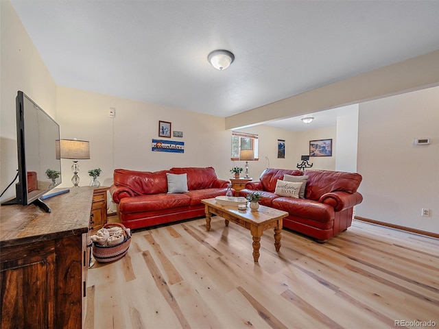 living area featuring light wood-style flooring and baseboards