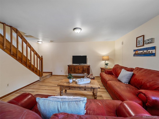 living room featuring stairs, wood finished floors, and baseboards