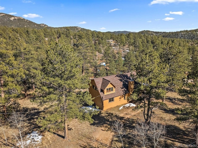 birds eye view of property featuring a mountain view and a wooded view