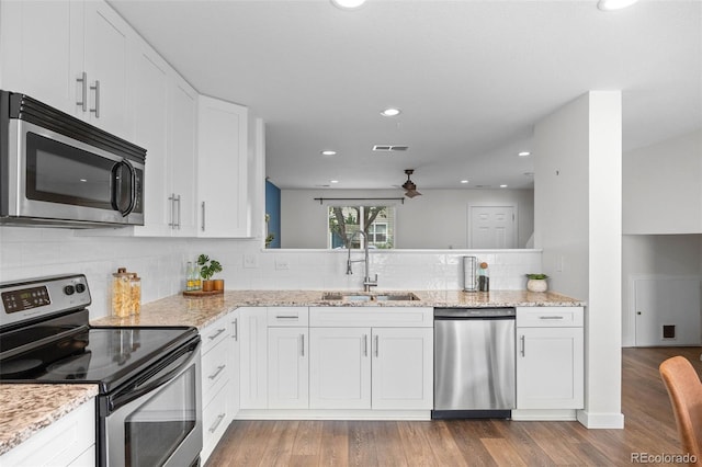 11845 W Tulane Dr, Morrison, CO 80465 - kitchen featuring appliances with stainless steel finishes, a ceiling fan, decorative backsplash, white cabinets, and wood finished floors
