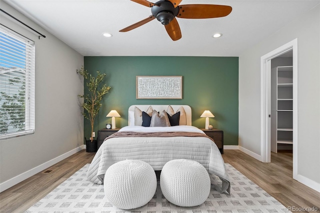 11845 W Tulane Dr, Morrison, CO 80465 - bedroom featuring an accent wall, multiple windows, recessed lighting, and wood finished floors