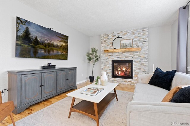 living room with light wood-style floors and a fireplace