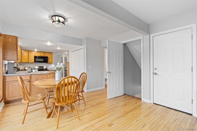 dining area with baseboards and light wood finished floors