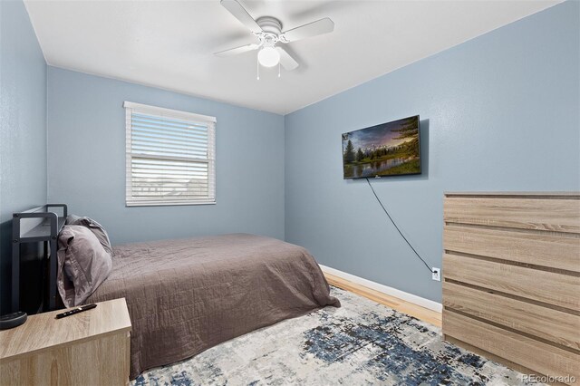 bedroom with baseboards, a ceiling fan, and wood finished floors