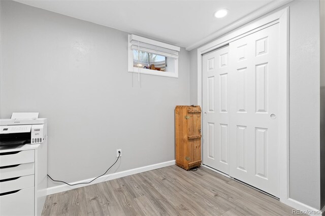 unfurnished bedroom with a closet, baseboards, and light wood-type flooring