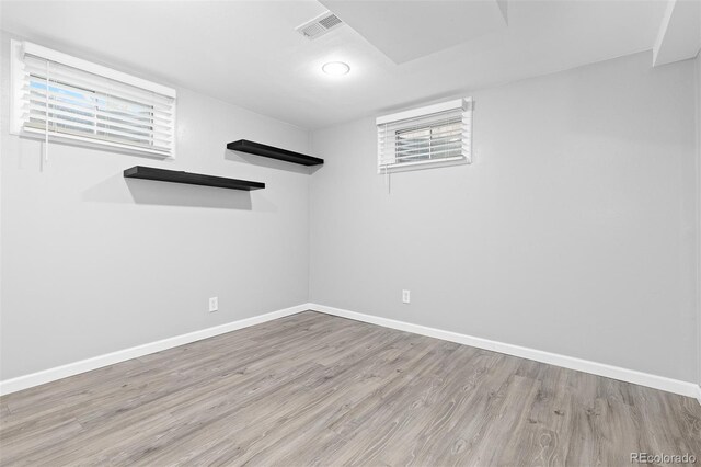 below grade area featuring baseboards, wood finished floors, and visible vents