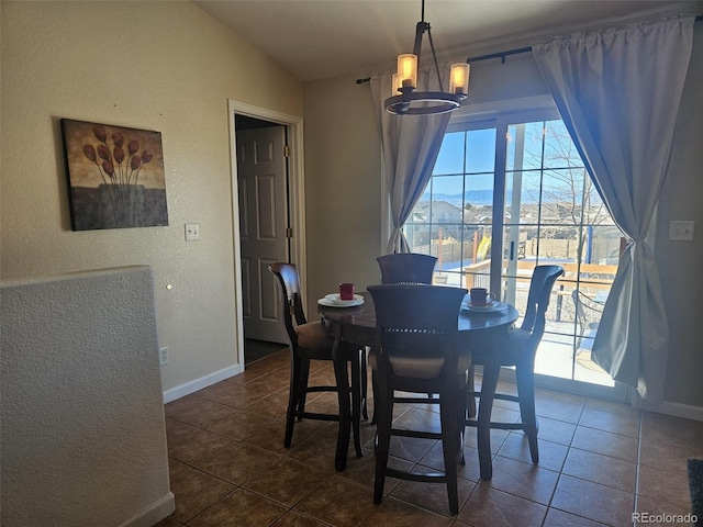 tiled dining area featuring a mountain view, an inviting chandelier, and vaulted ceiling