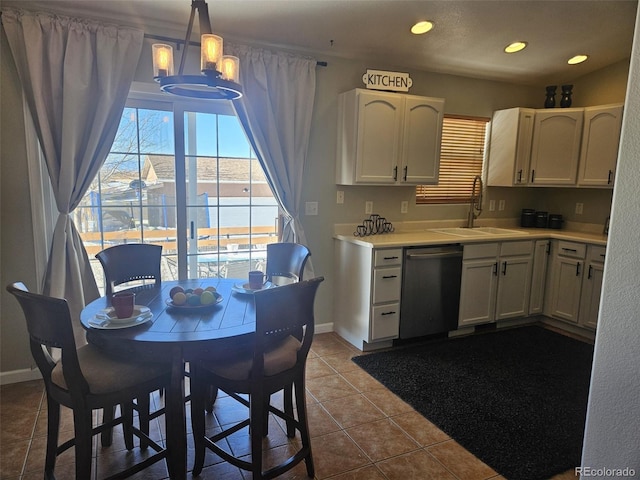 kitchen with stainless steel dishwasher, decorative light fixtures, white cabinets, and sink