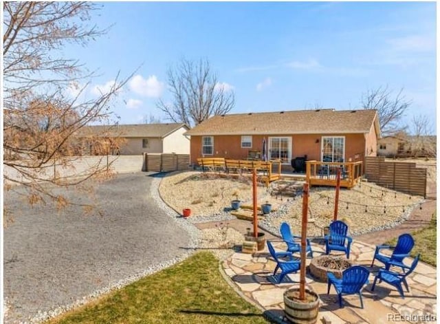 rear view of property with a patio and a fire pit