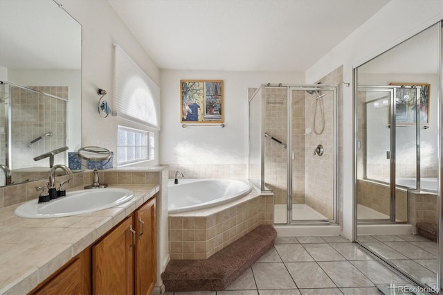 bathroom with tile patterned floors, vanity, and shower with separate bathtub