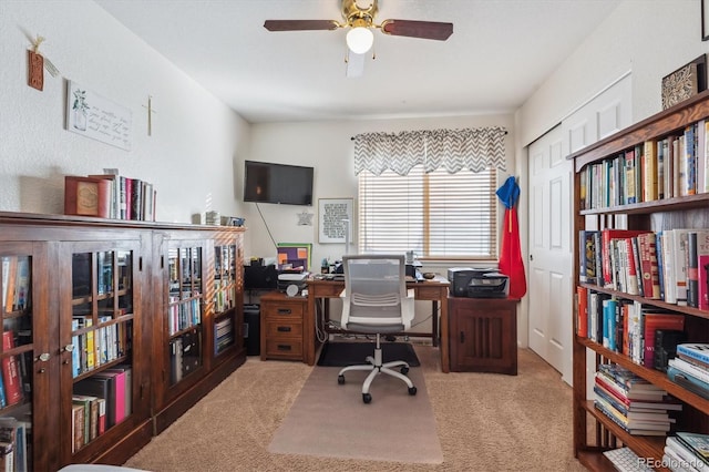 carpeted office featuring ceiling fan