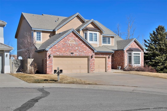 traditional-style home with a tile roof, concrete driveway, and brick siding