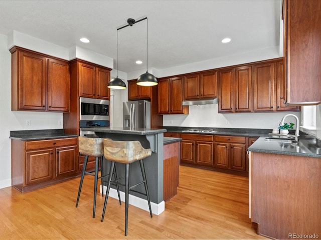 2880 Emporia Ct, Denver, CO 80238 - kitchen featuring a sink, appliances with stainless steel finishes, dark countertops, a kitchen bar, and recessed lighting
