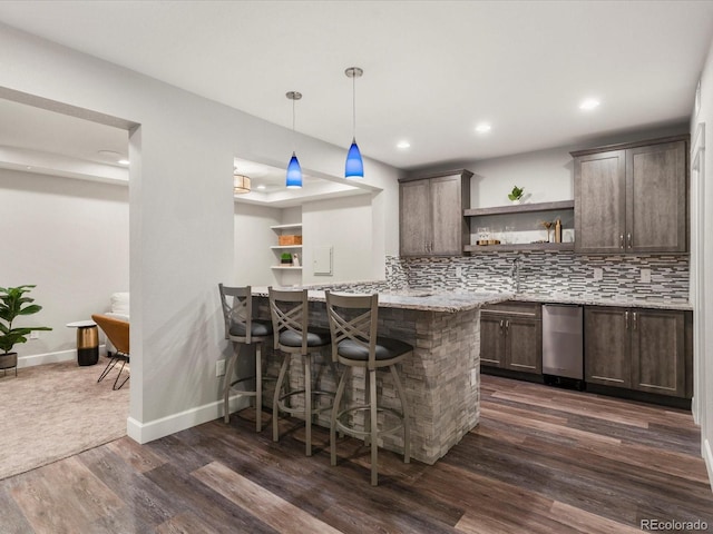 2880 Emporia Ct, Denver, CO 80238 - kitchen with open shelves, dark wood-type flooring, dark brown cabinetry, a breakfast bar area, and backsplash