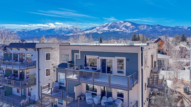 view of front facade with a mountain view, stucco siding, and stairway