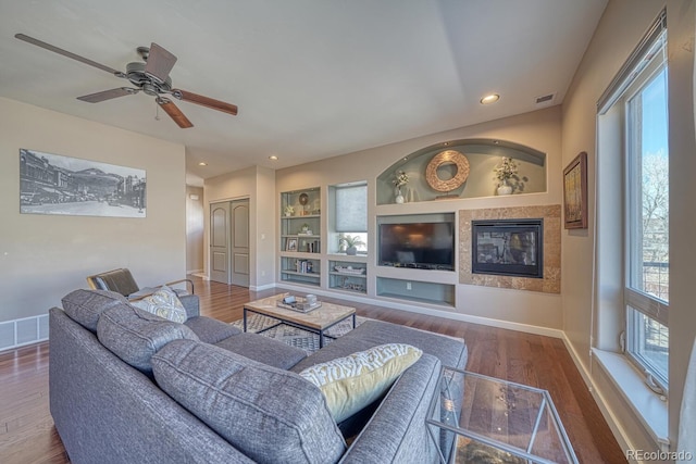 living area featuring recessed lighting, visible vents, baseboards, and wood finished floors