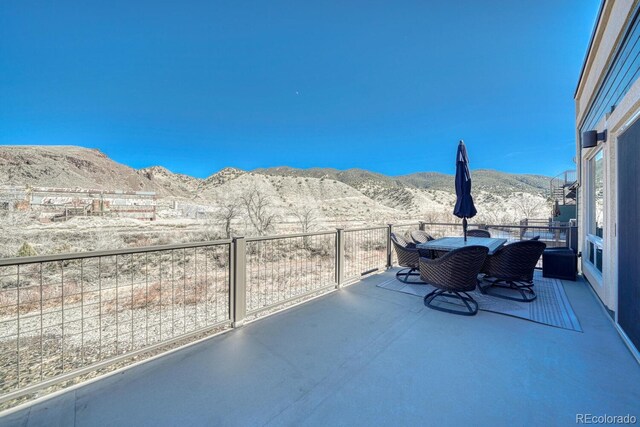 view of patio featuring a mountain view and a balcony