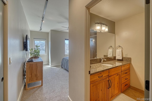 bathroom with track lighting, vanity, baseboards, and a ceiling fan