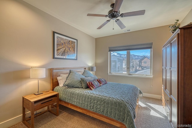 bedroom featuring visible vents, light colored carpet, baseboards, and ceiling fan