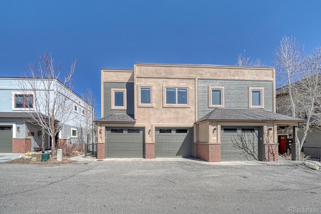 multi unit property featuring brick siding, stucco siding, cooling unit, and a garage