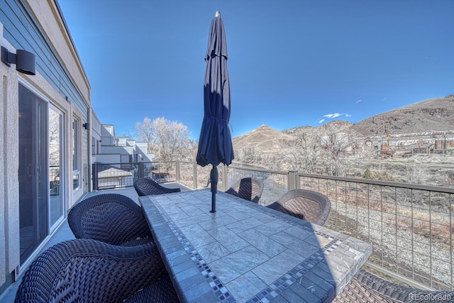 balcony with a mountain view and outdoor dining space