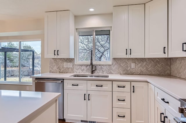 kitchen featuring a sink, white cabinetry, light countertops, decorative backsplash, and dishwasher