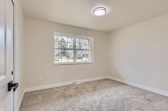 spare room with carpet flooring, visible vents, and baseboards