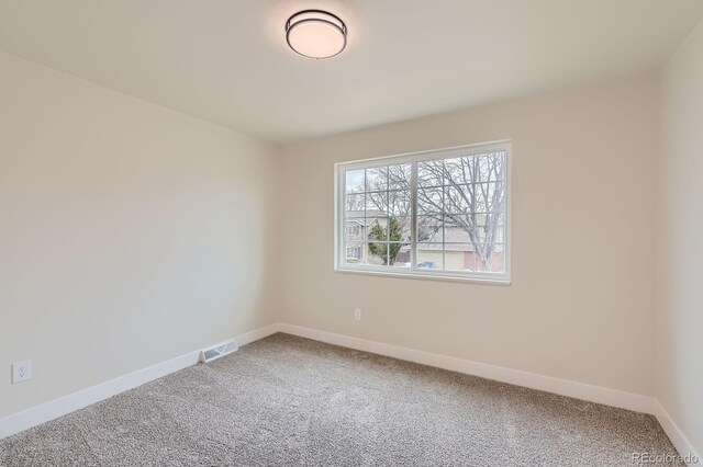 carpeted empty room with visible vents and baseboards