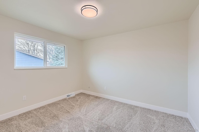 spare room with visible vents, light carpet, and baseboards