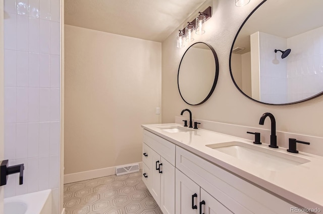 bathroom with double vanity, tile patterned flooring, baseboards, and a sink