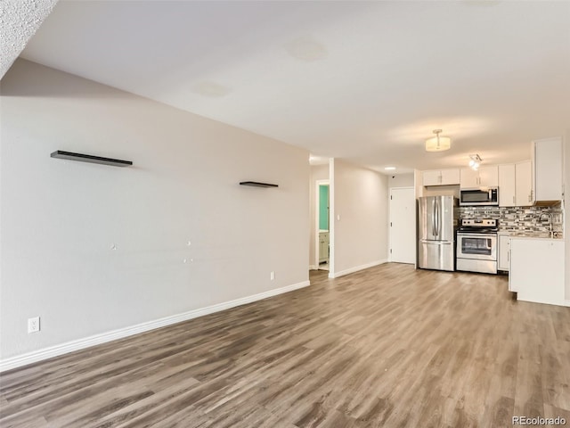 unfurnished living room with light hardwood / wood-style flooring and sink