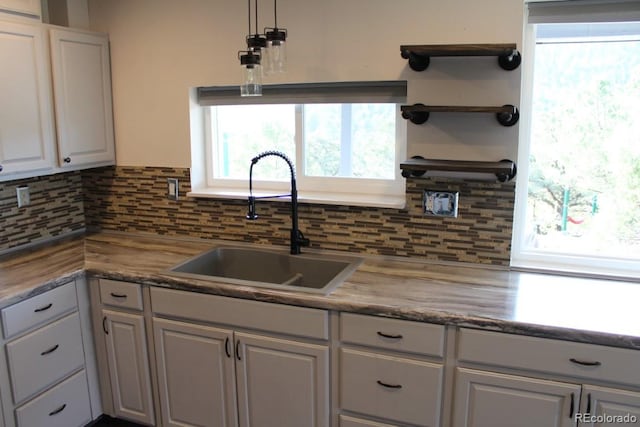 kitchen featuring sink, tasteful backsplash, and white cabinets