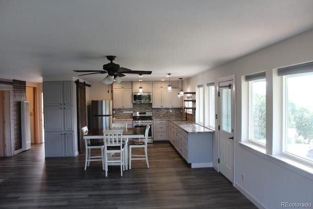 kitchen with decorative backsplash, stainless steel appliances, decorative light fixtures, and dark wood-type flooring