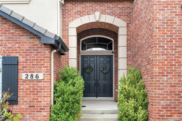 view of exterior entry featuring brick siding