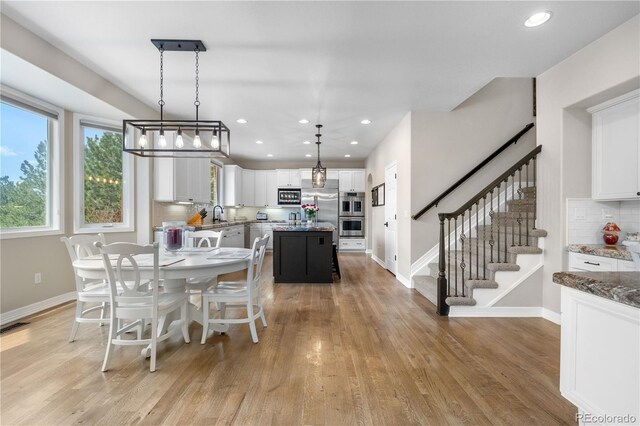 dining area with stairway, baseboards, recessed lighting, and light wood finished floors