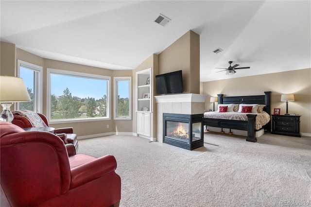 carpeted bedroom featuring baseboards, visible vents, lofted ceiling, and a fireplace