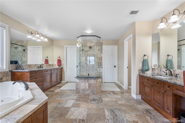 bathroom with a sink, a whirlpool tub, a stall shower, and visible vents