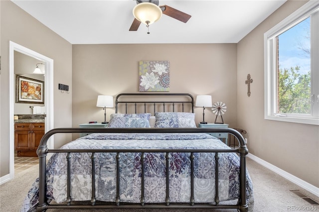 bedroom with baseboards, ensuite bathroom, and carpet