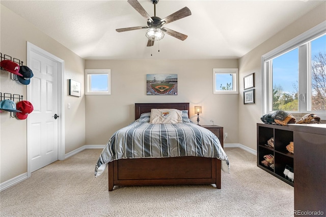 bedroom featuring light colored carpet, baseboards, and ceiling fan