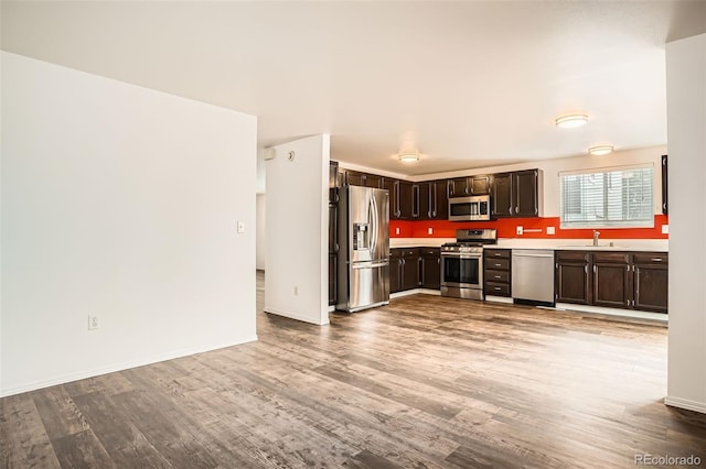 8057 Bryant St, Westminster, CO 80031 - kitchen featuring appliances with stainless steel finishes, light countertops, wood finished floors, and dark brown cabinets