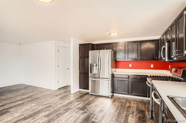 8057 Bryant St, Westminster, CO 80031 - kitchen with stainless steel appliances, wood finished floors, light countertops, and dark brown cabinetry