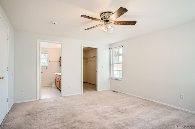 8057 Bryant St, Westminster, CO 80031 - unfurnished bedroom featuring multiple windows, light carpet, a walk in closet, and ensuite bathroom